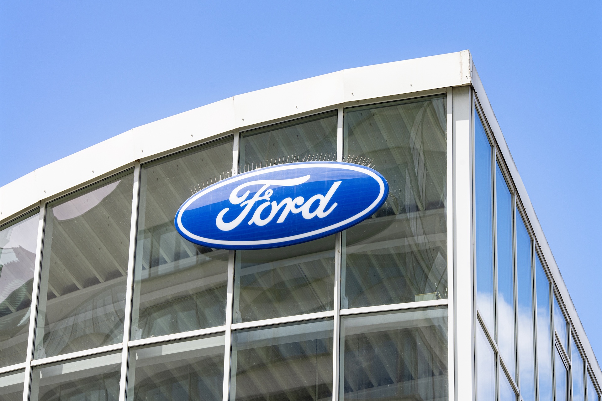 Ford logo on the glass facade of a car dealership