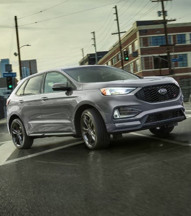 Mujer con gafas conduciendo un vehículo nuevo.